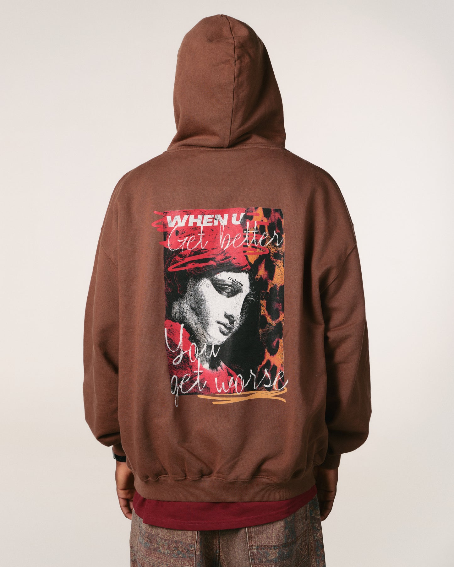 Brown hoodie with graphic design on the back against a white background